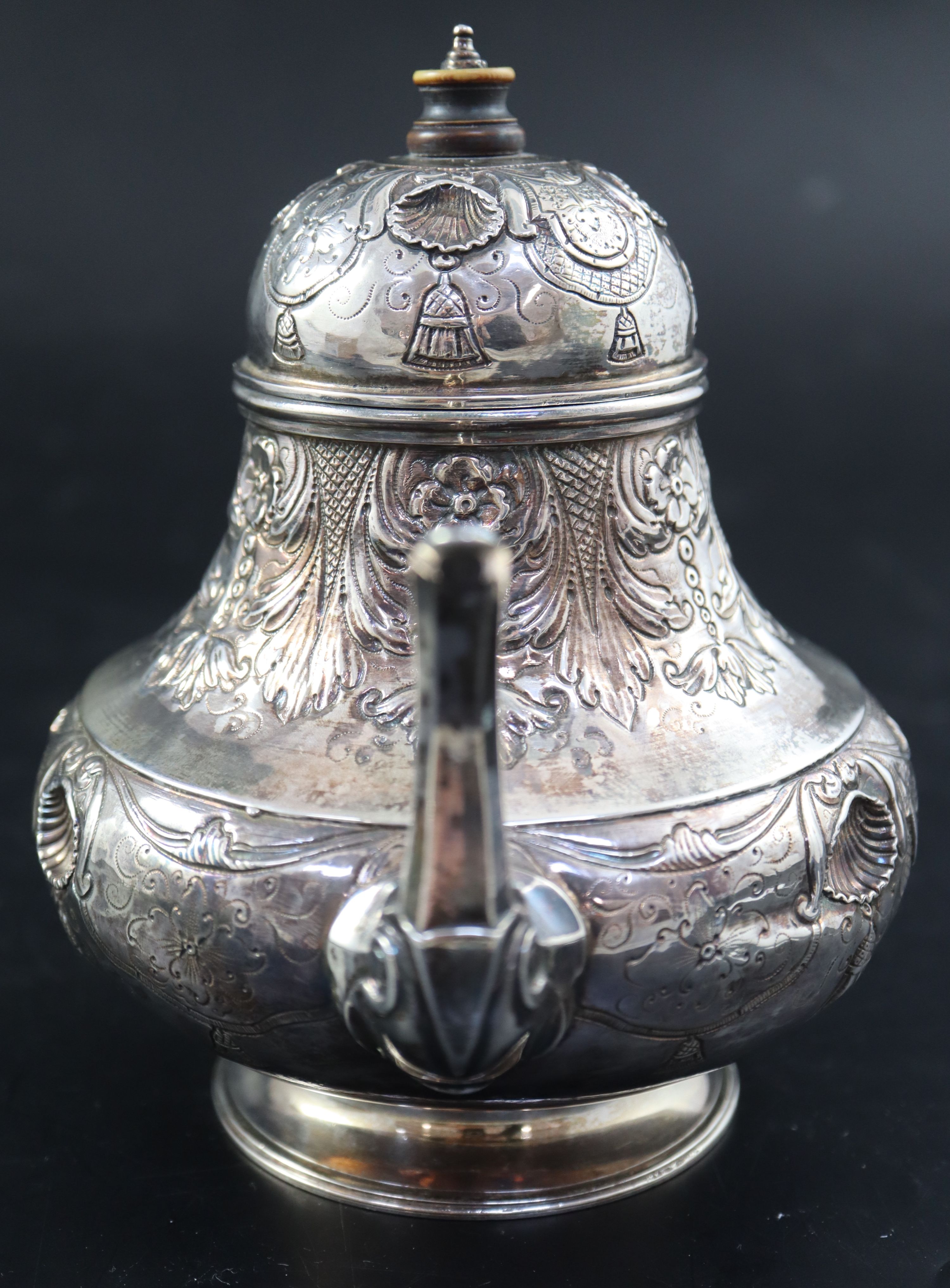 A late 18th/early 19th century Dutch embossed white metal pear shaped teapot, height 15.3cm, gross 10oz.